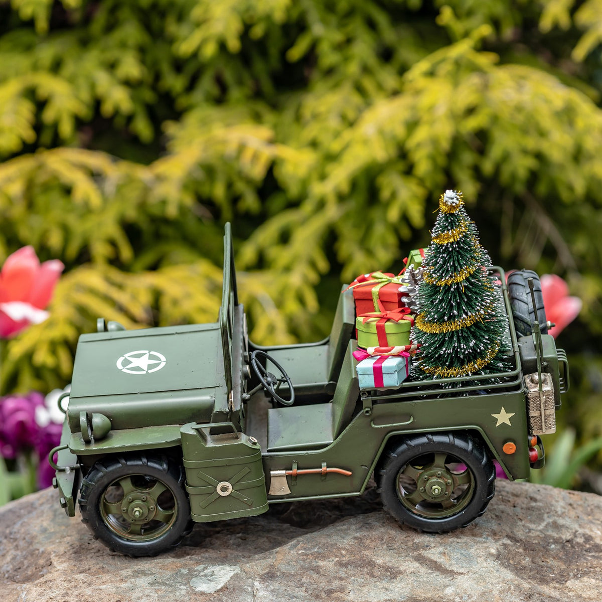 Army-green military vehicle with tree and gifts, opposite side view outdoors
