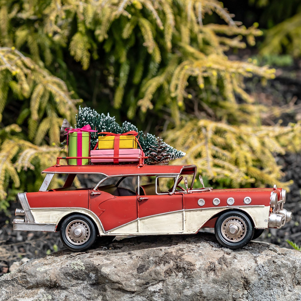 Side profile of the red-and-ivory vintage-style wagon with tree and gifts