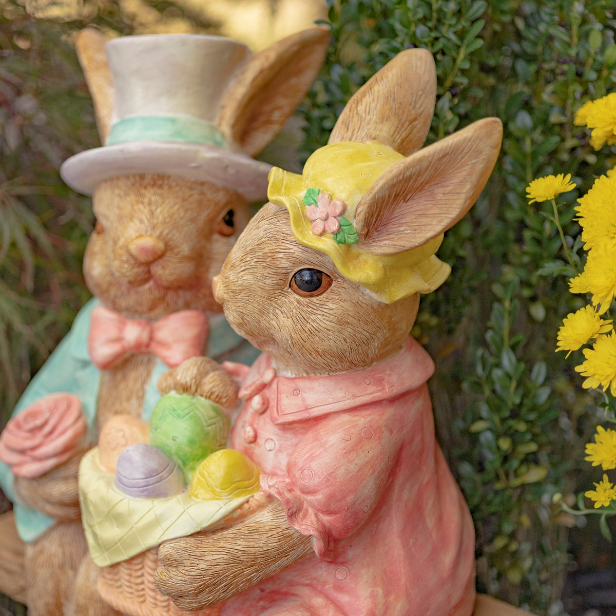 A close view of the rabbit in a yellow bonnet, with the other rabbit partly visible behind.