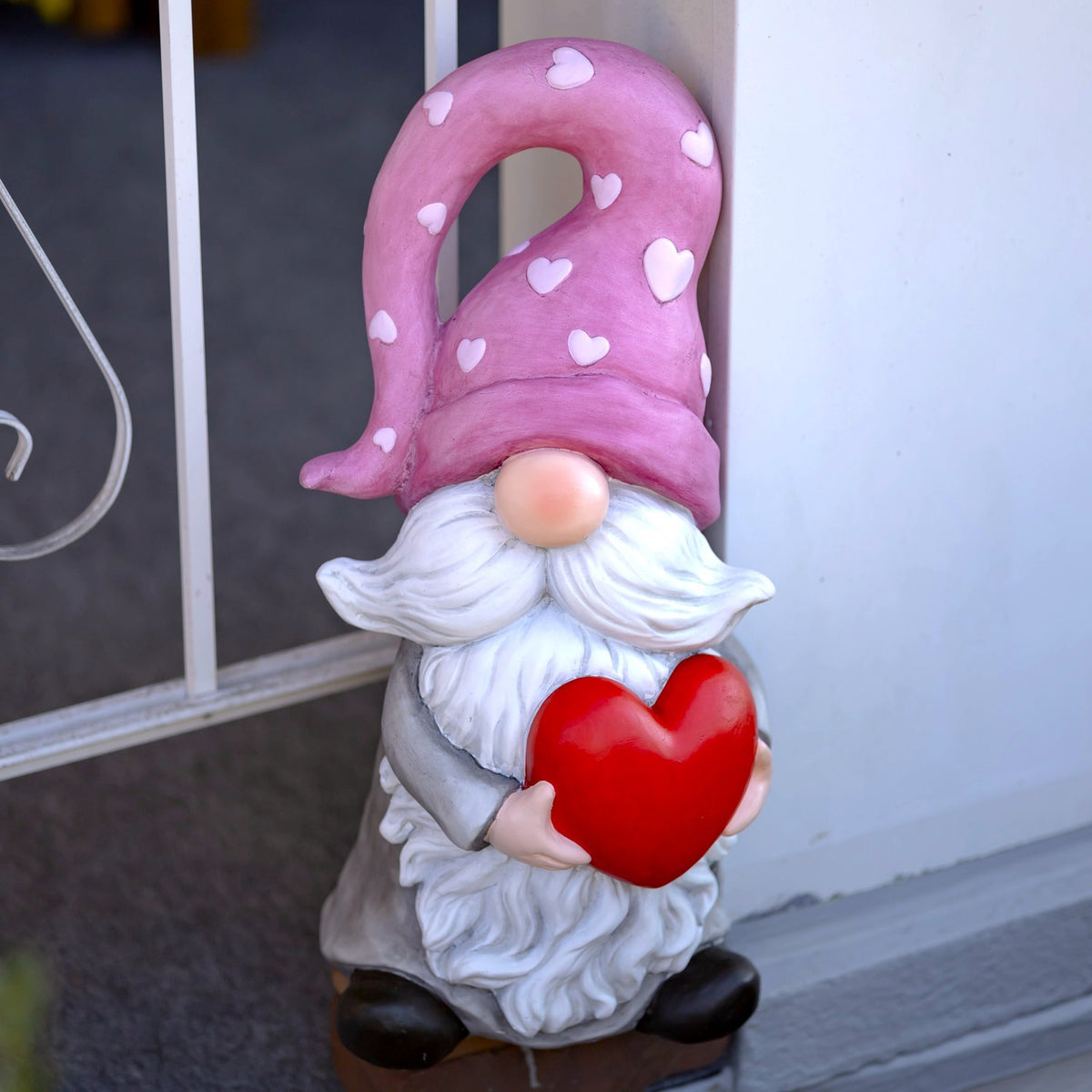 Heart-holding gnome beside a doorway, shown from the front