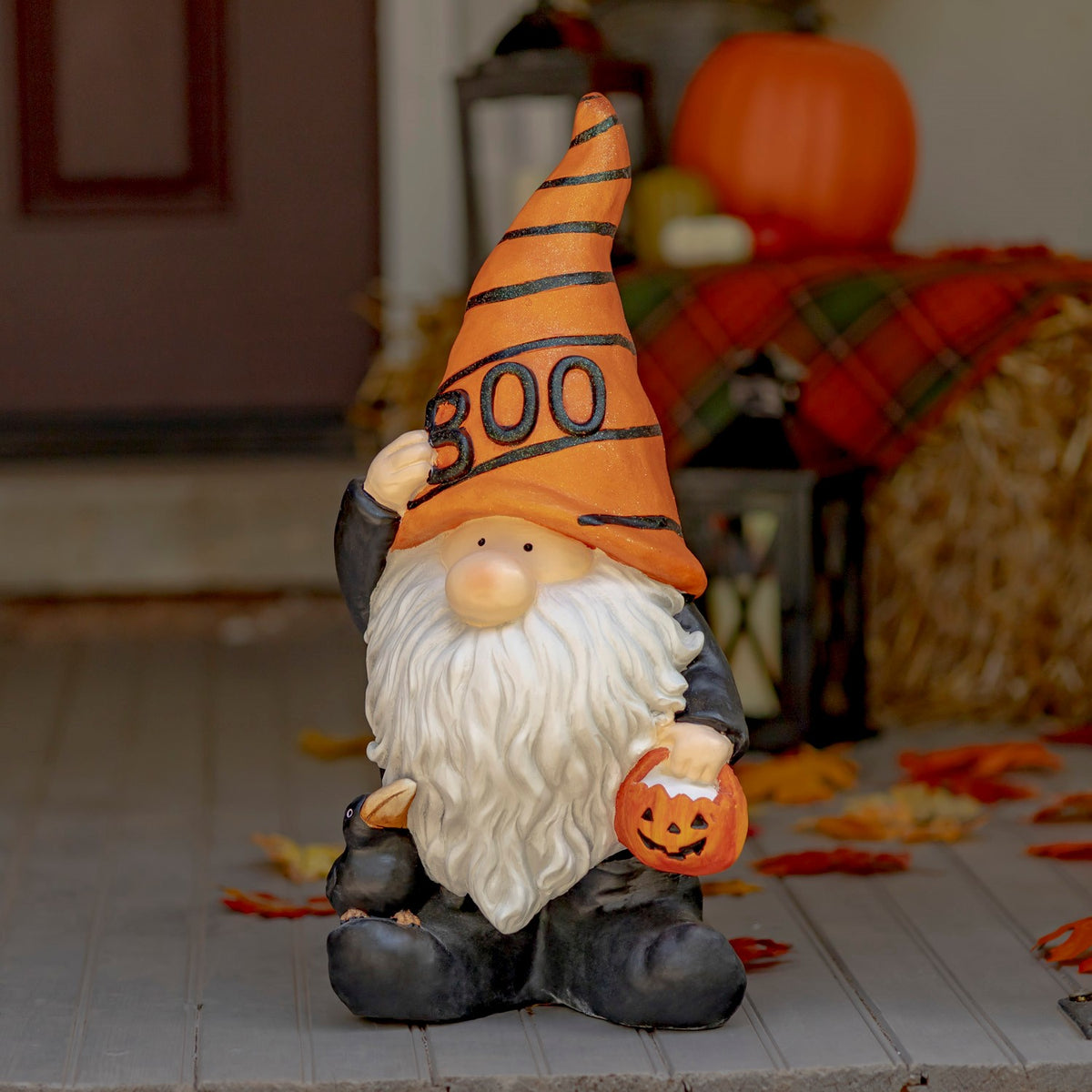Halloween gnome in an orange BOO hat holding a small pumpkin