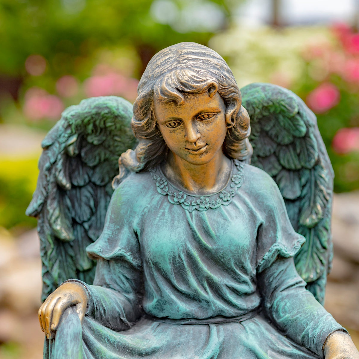The angel looks down between its wings, with the head, shoulders, and upper robe in focus.
