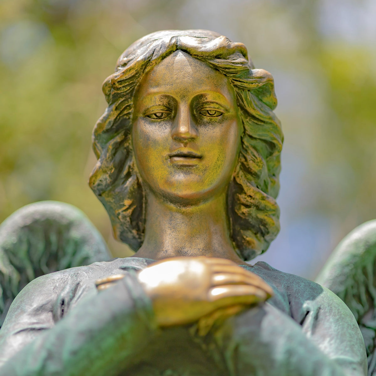 Close-up of the angel's calm face and wavy hair, with its hands partly visible below.