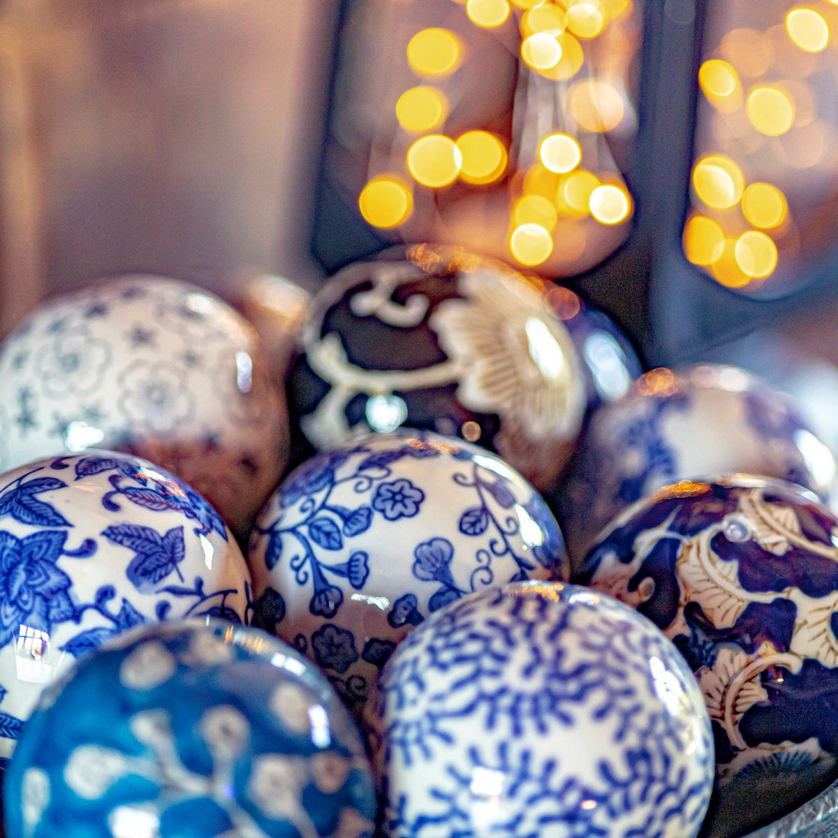 Close-up of glossy ceramic balls with blue floral patterns and a dark floral design.