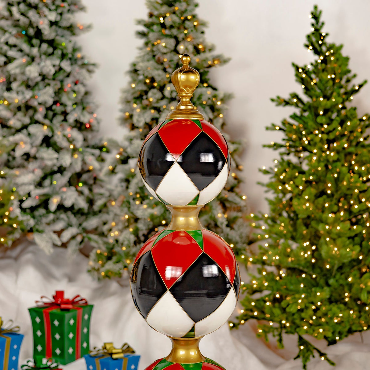 The upper two patterned ornaments and gold connectors are shown against a backdrop of lit Christmas trees.