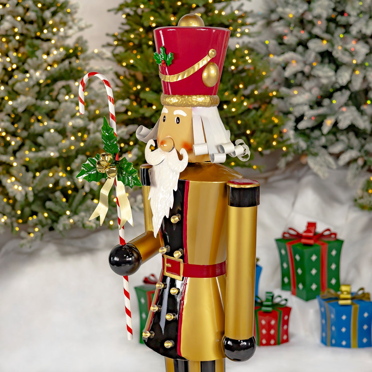 Three-quarter side view showing the nutcracker’s gold coat, black cuffs, candy cane, and profile.