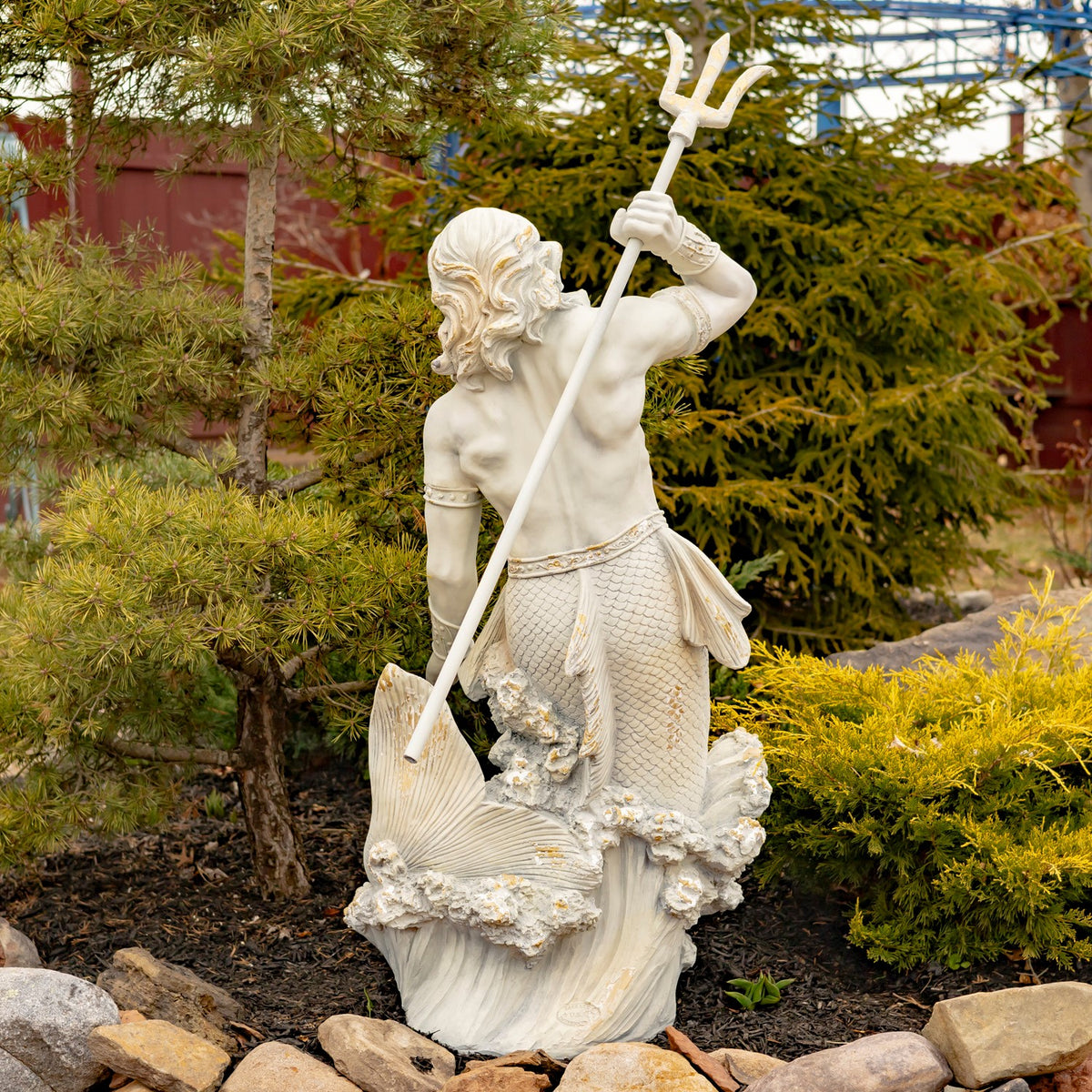 Back view of the merman statue showing its flowing hair, scaled tail, and diagonally held trident.