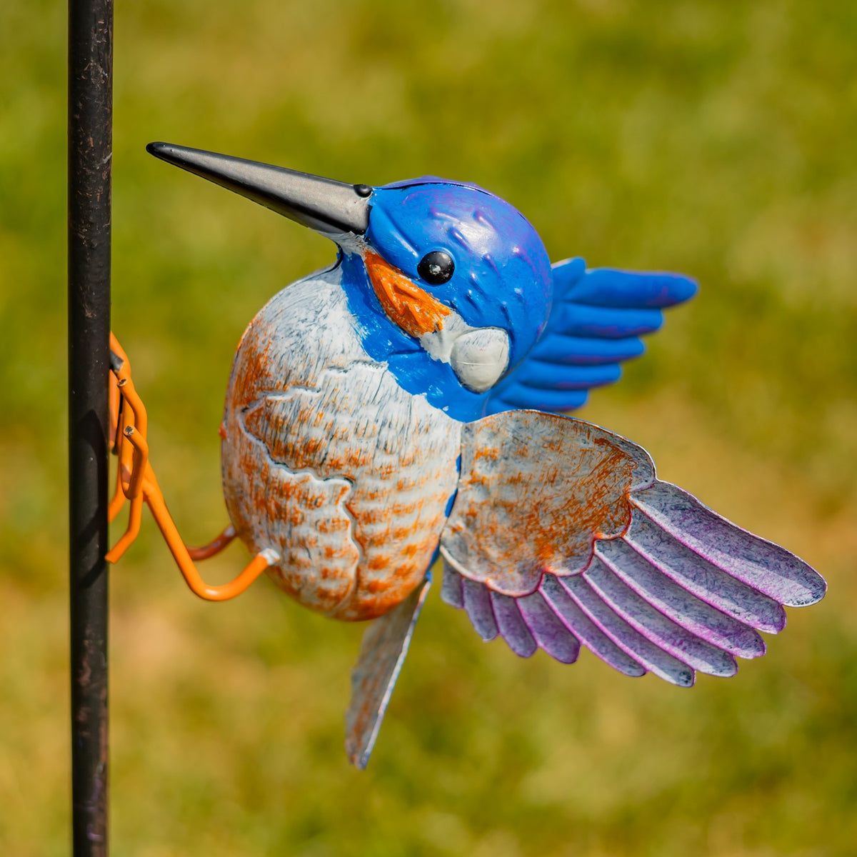 Close-up of the blue, white, and orange iron hummingbird sculpture