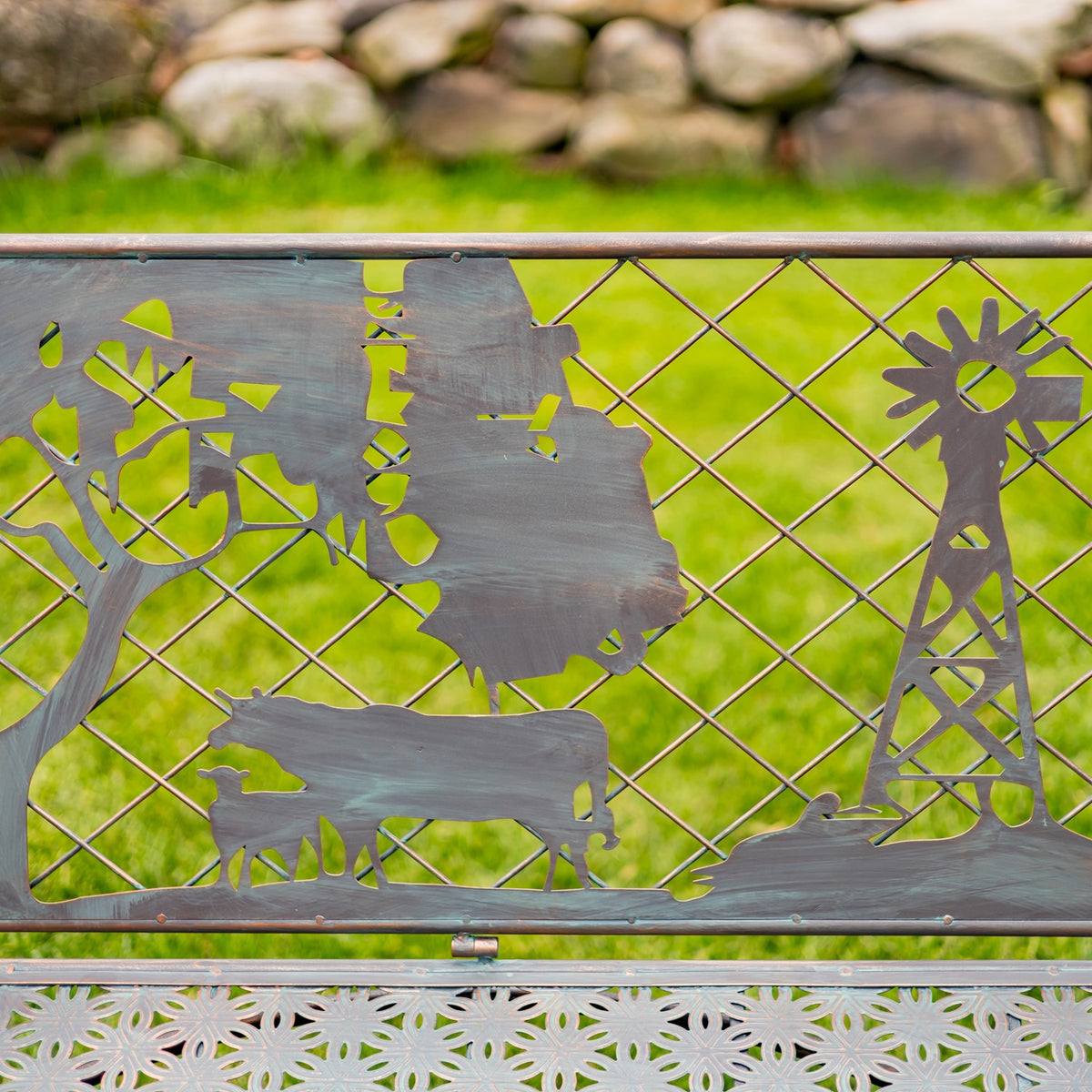 Close-up of the backrest’s cow, tree and windmill cutouts against the garden background.