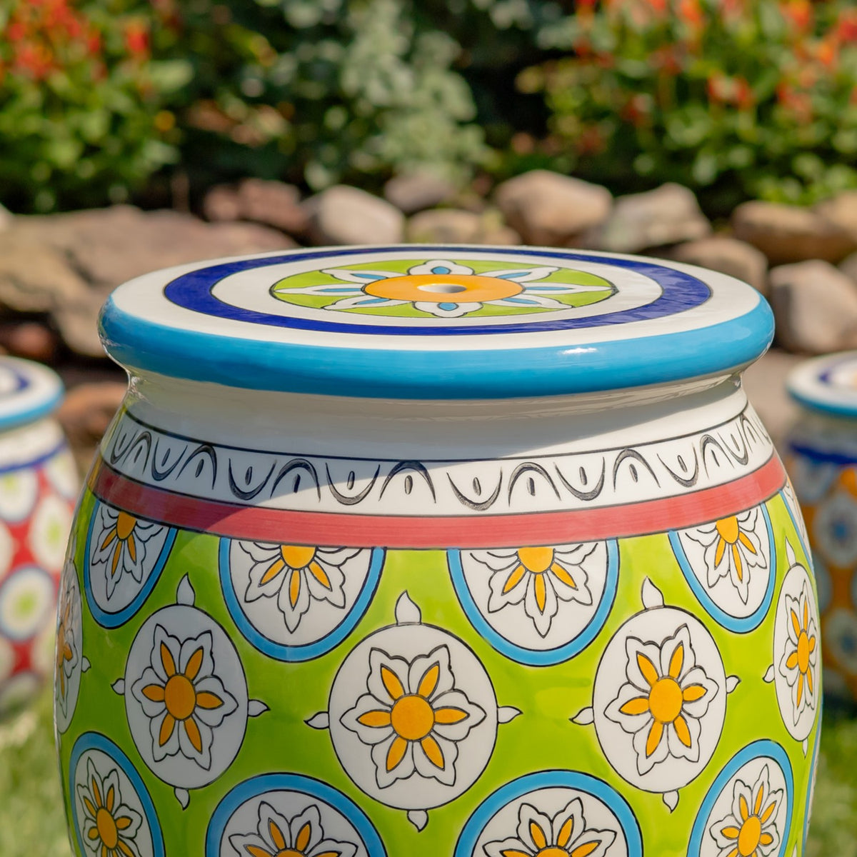 Side view highlighting the stool's rounded shape, blue seat rim, and repeating floral decoration.