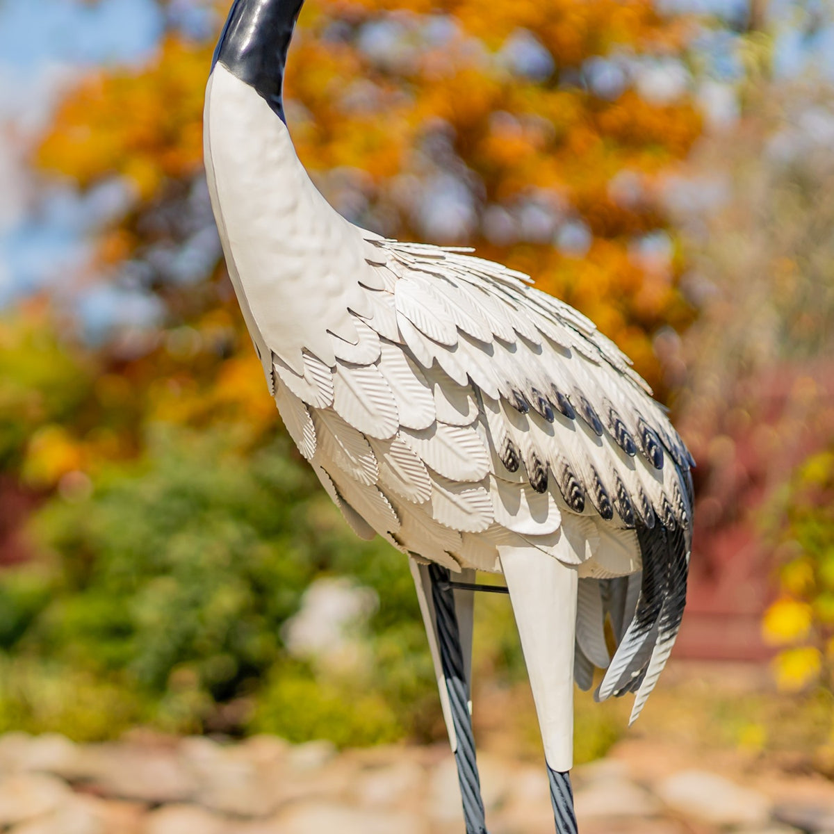 Close view of a crane figurine's layered white and dark feather details