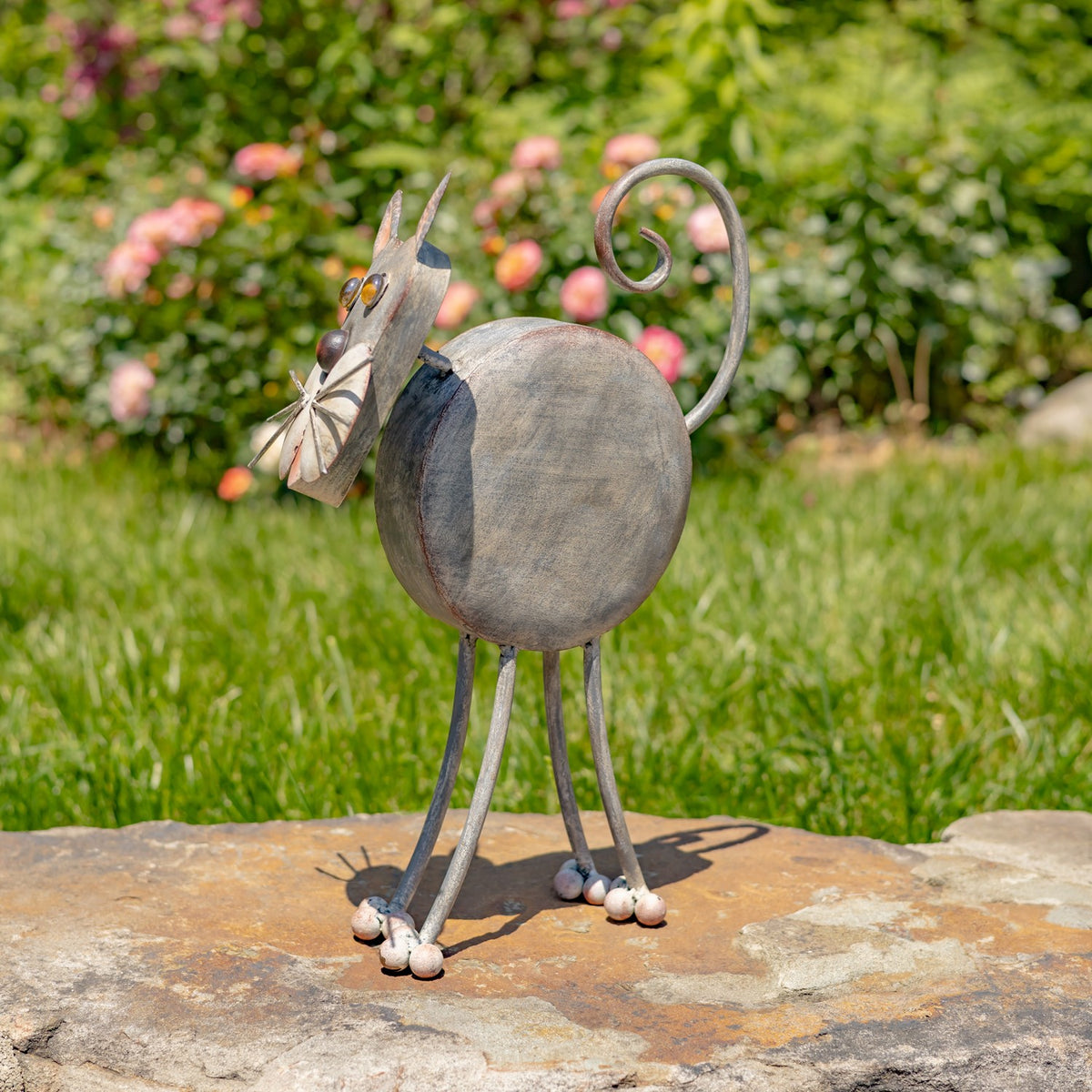 Side view showing the iron cat planter's rounded body and curled tail