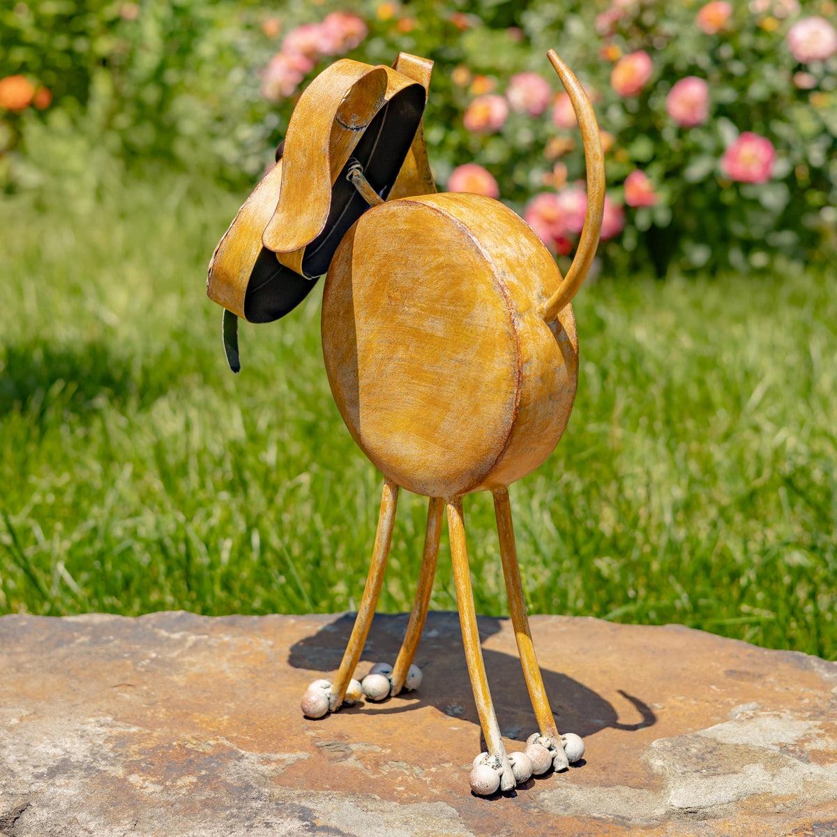 Rear three-quarter view of the rust-gold iron dog planter outdoors