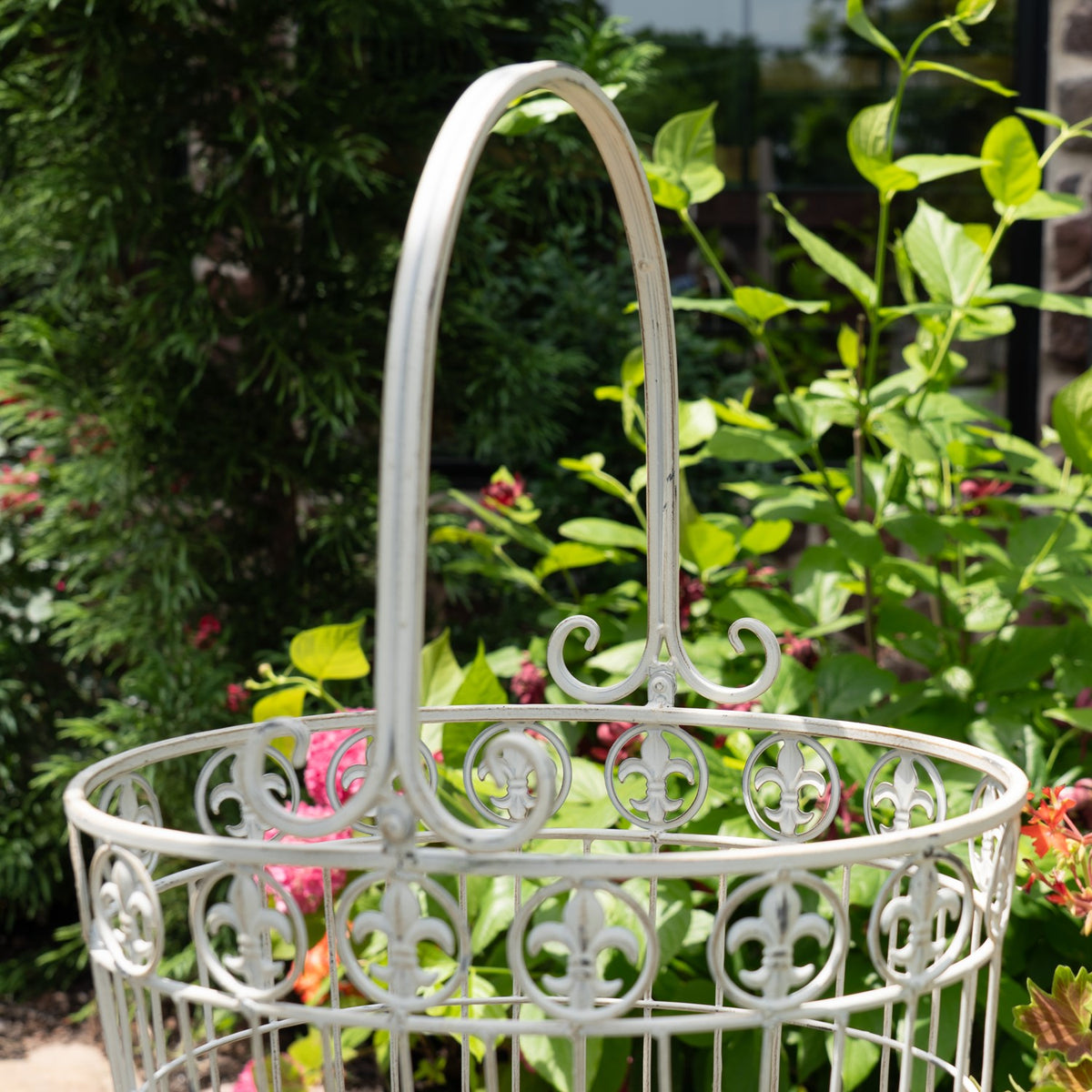 Close view of a pale metal basket showing its arched handle and scrolling circular wirework.