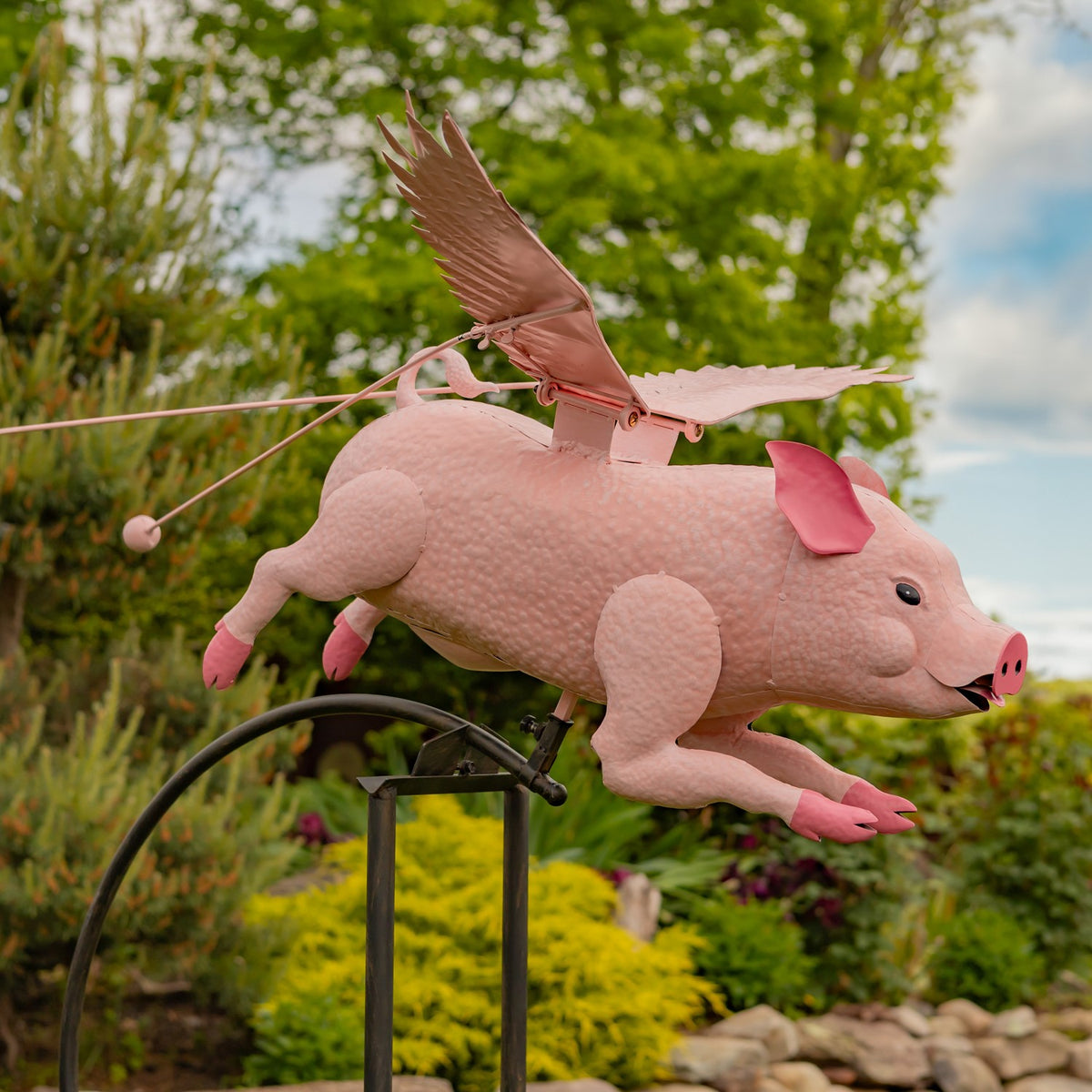 Side view of the pink pig with wings extended above the garden stake