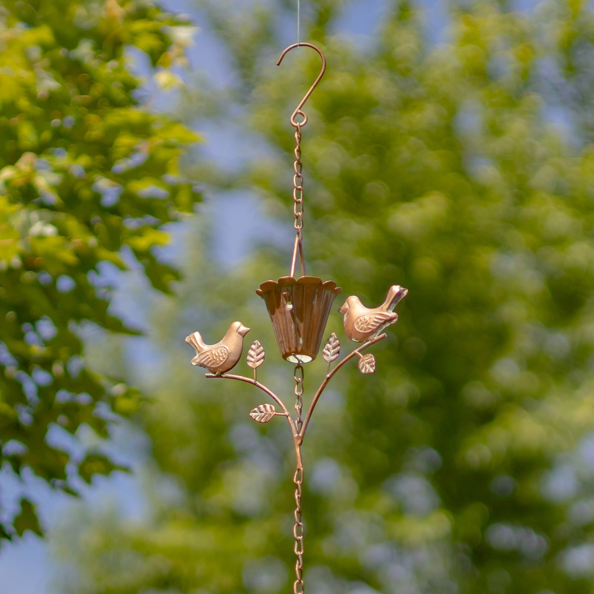 Curved hanging hook and chain above a bird-and-leaf ornament with a central fluted cup.