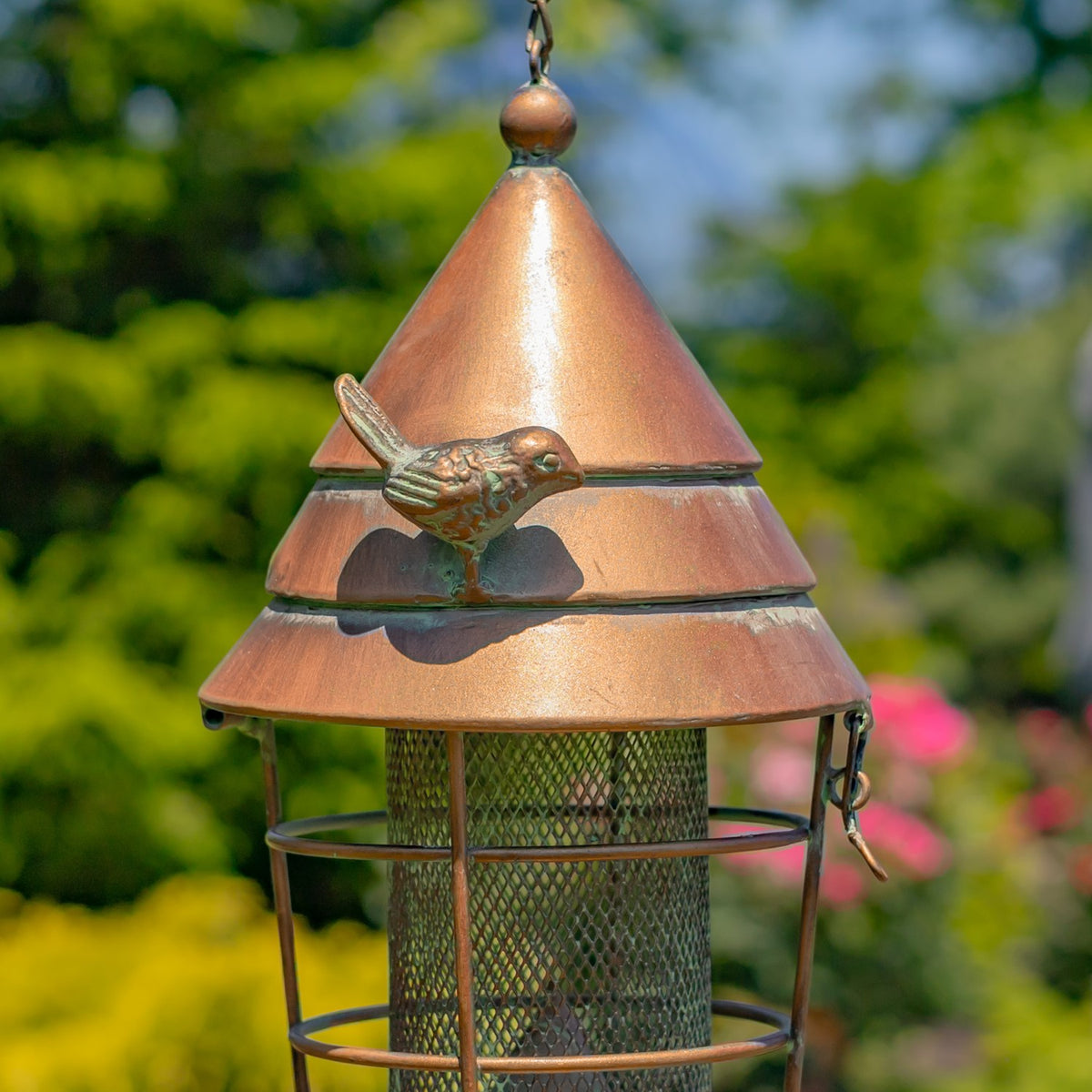 Small bird accent on the copper-toned feeder roof, shown close up