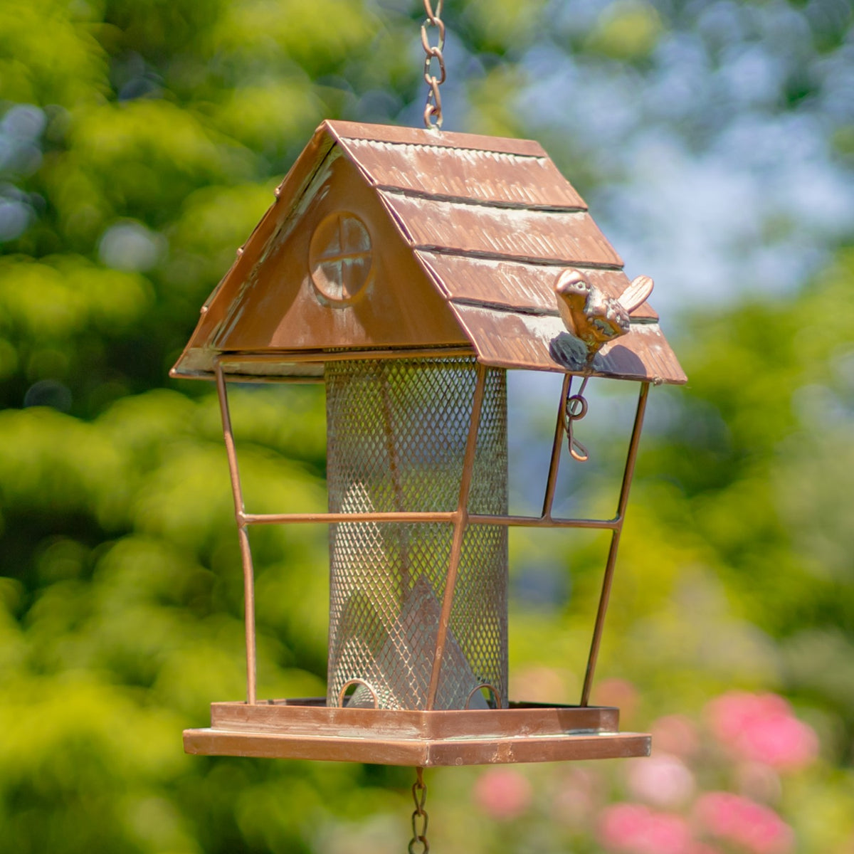Angled view of the metal bird feeder roof with a small bird ornament