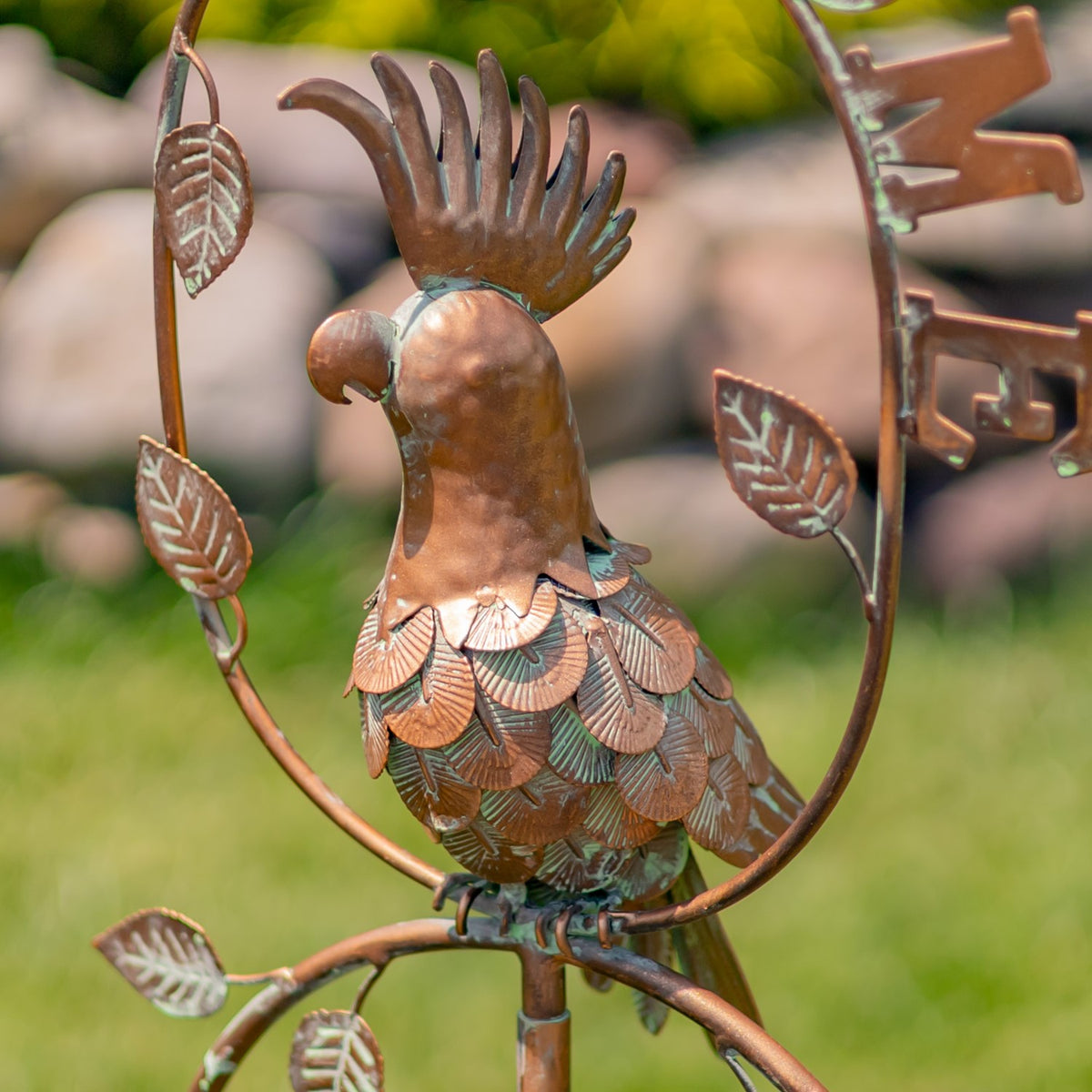Close-up of the metal cockatoo’s raised crest, rounded head and overlapping feather shapes.