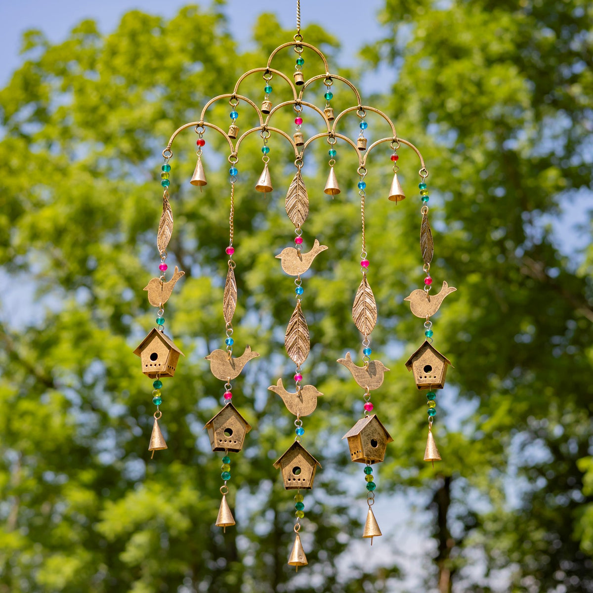 Ornate hanging chime with gold-colored bird and leaf ornaments suspended among colorful beads.