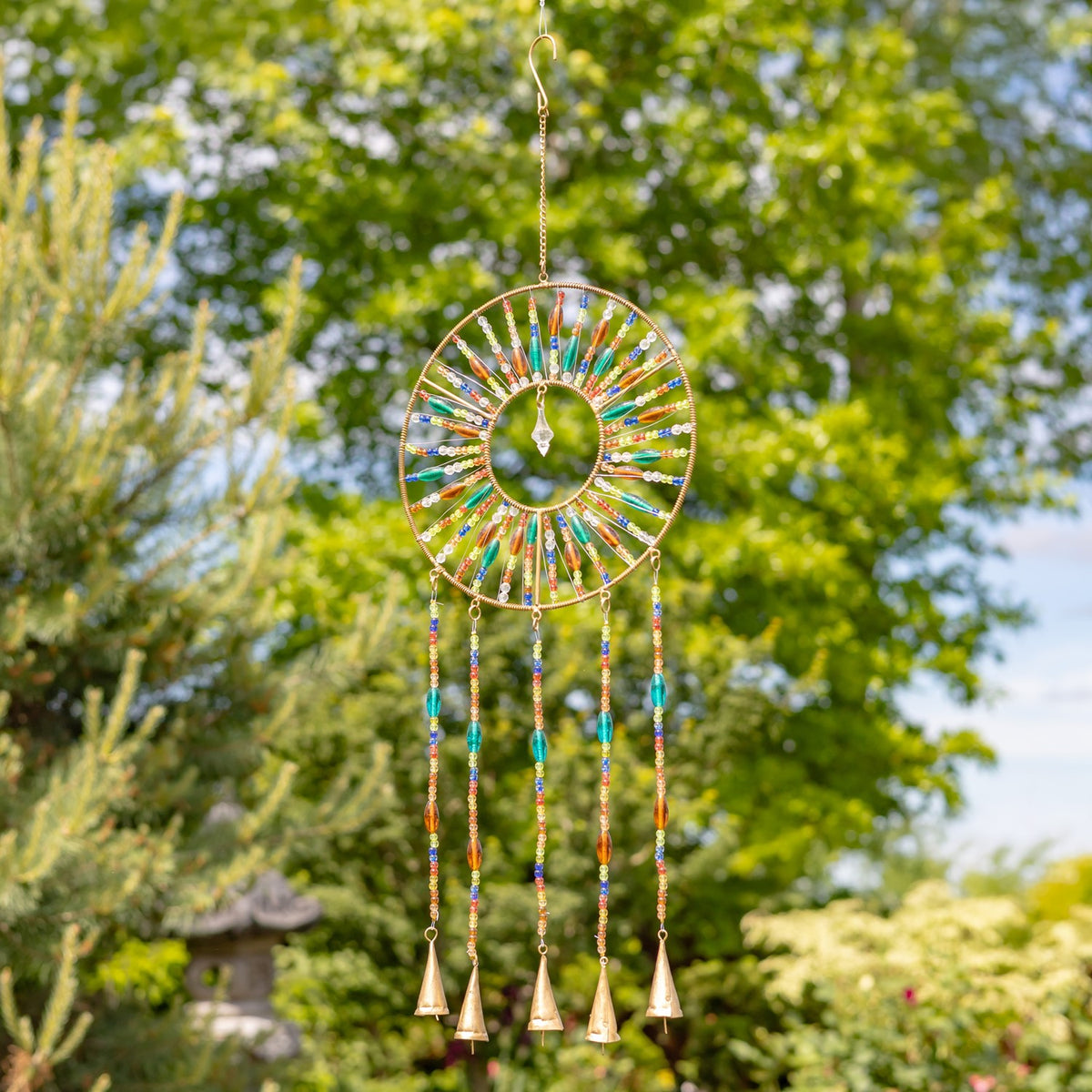 Circular metal wind chime decorated with bright beads, a central dangling ornament, and four hanging bells.