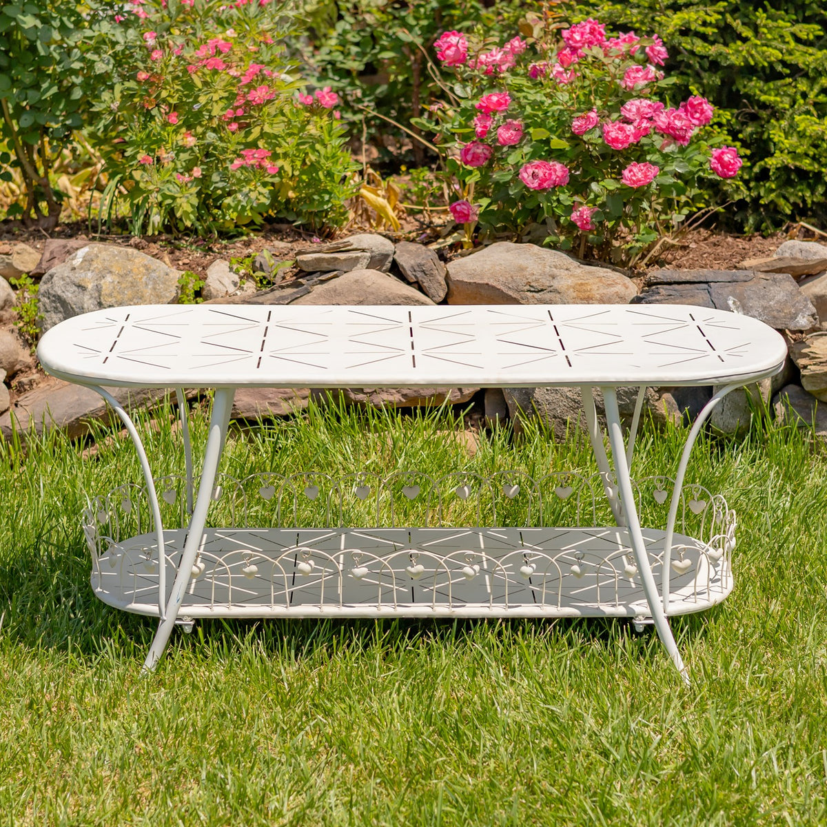 Antique white oval garden table in a straight-on view on grass