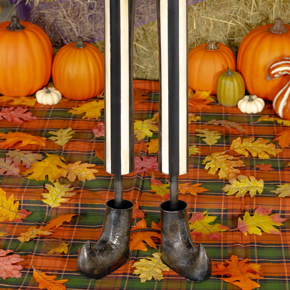 Close-up of the skeleton's long striped legs and dark boots against a leaf-patterned display cloth.
