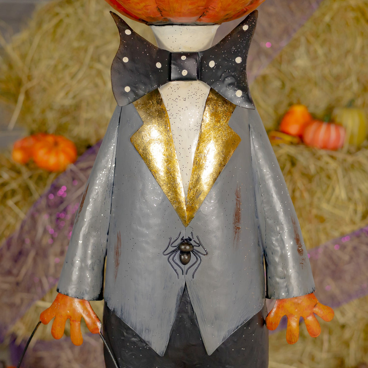 Close-up of the figure's grey jacket, spotted bow tie and small spider detail