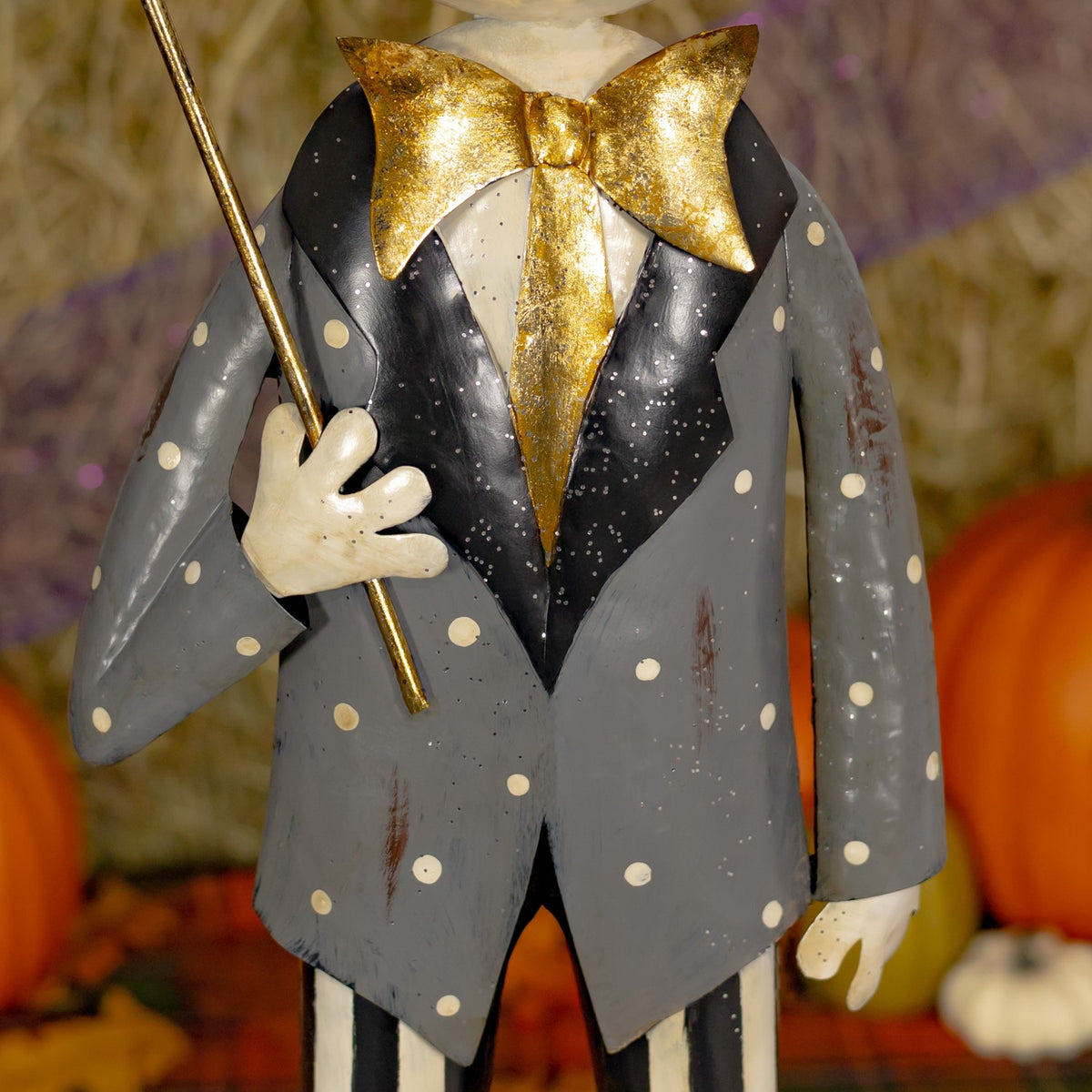 Close-up of the skeleton boy's dotted coat, gold bow, and umbrella handle