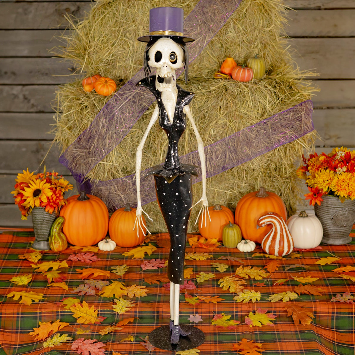 Single skeleton figurine in a purple top hat against a Halloween display