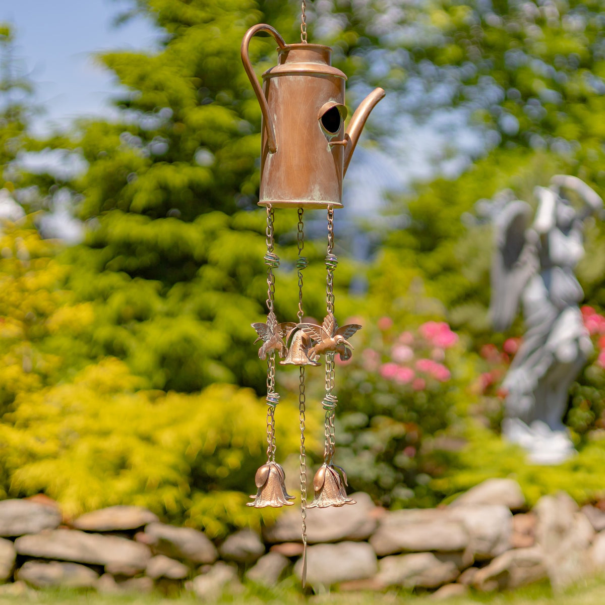 Side profile of a narrow teapot-shaped wind chime with butterfly details and hanging bells.