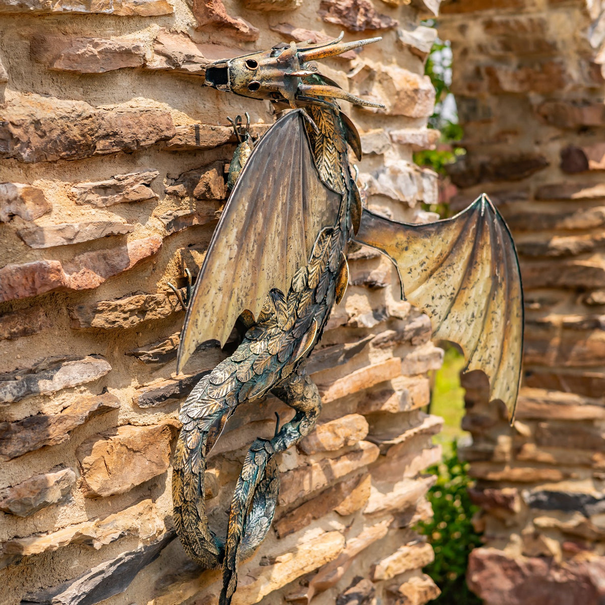 Angled view of the wall-mounted dragon, showing its raised head, wings and slender body.