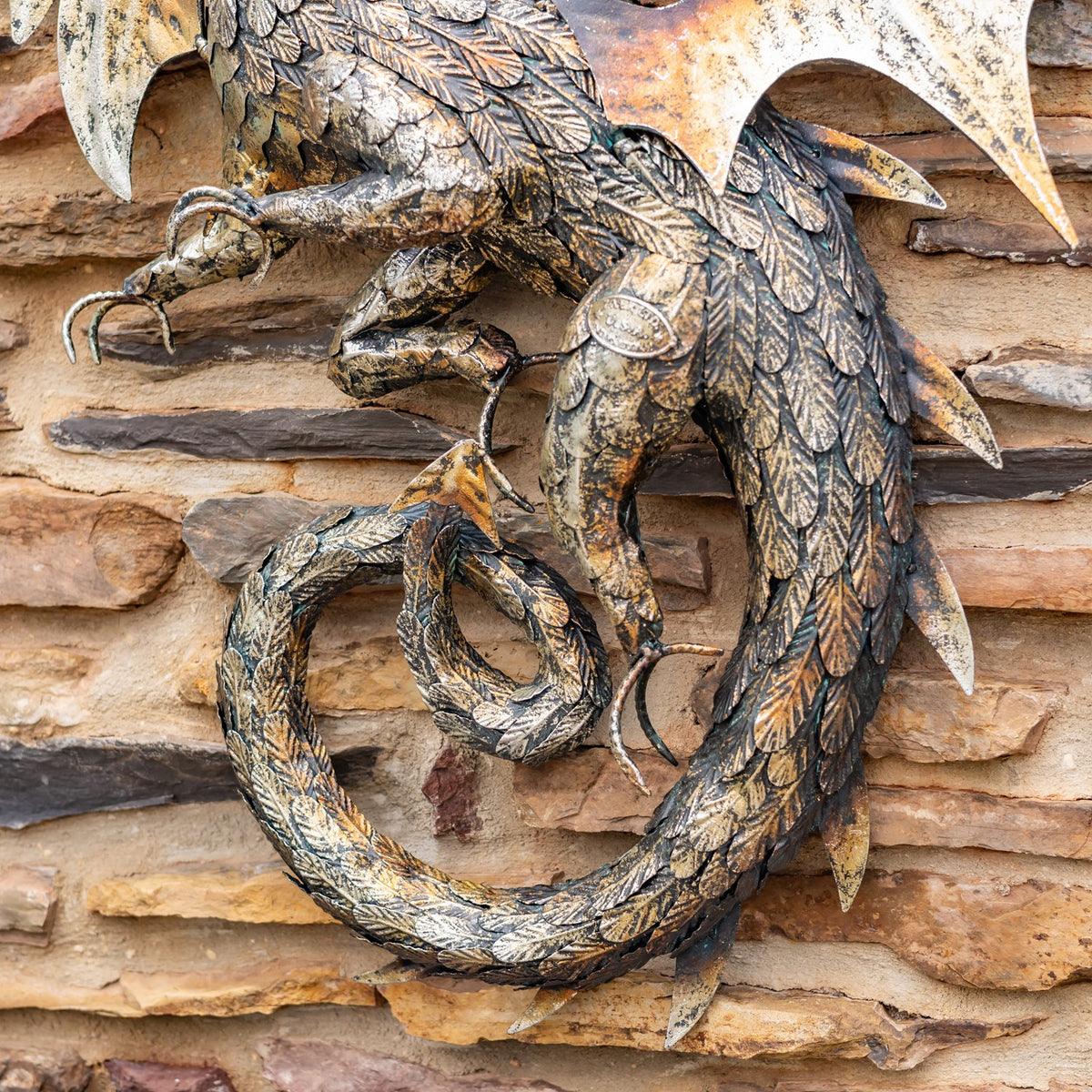 Close view of the dragon’s curled, textured tail beneath its scaled body.