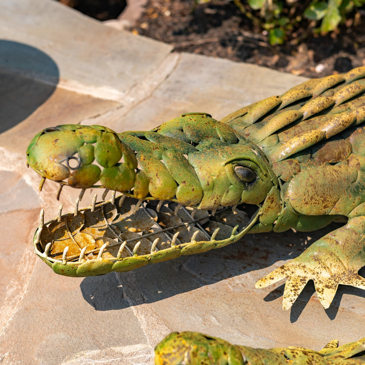 Close view of an alligator decoration's eye, textured snout, open mouth, and pointed teeth.