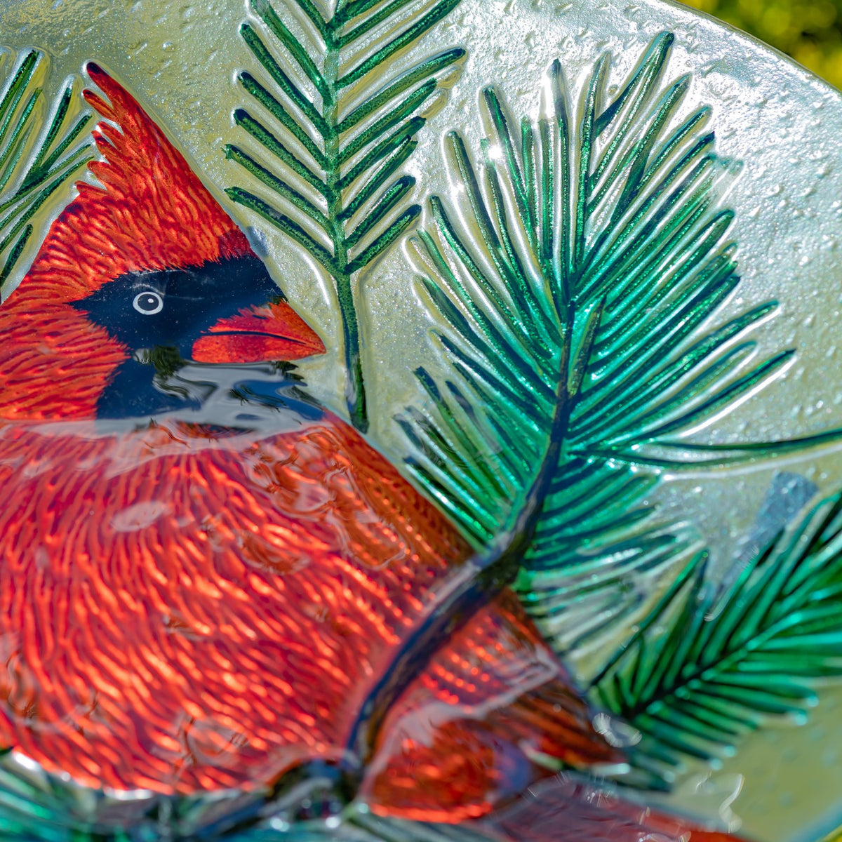 Close-up of the cardinal motif and glossy green evergreen details on the bowl