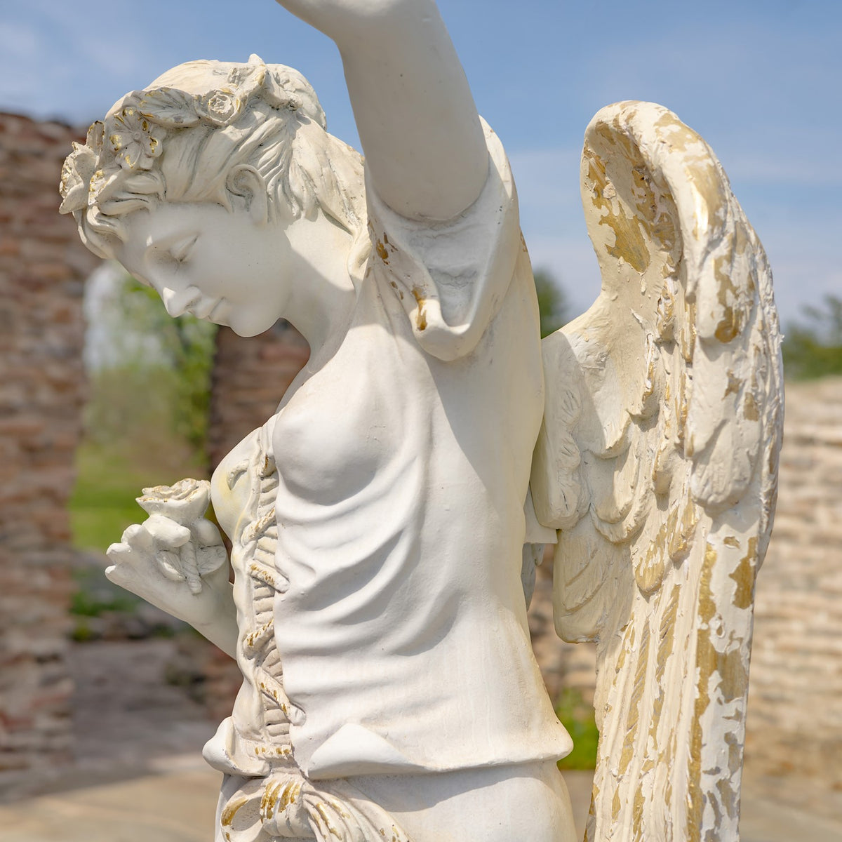 Side view highlighting the angel’s draped clothing, raised arm, and textured wing.