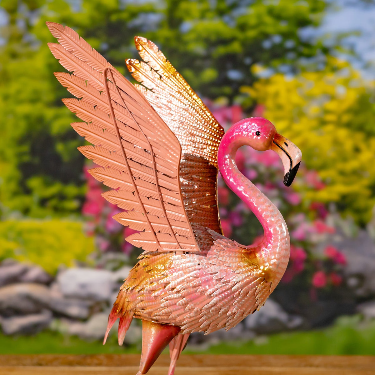 A pink flamingo figurine shown in profile with one large wing raised.