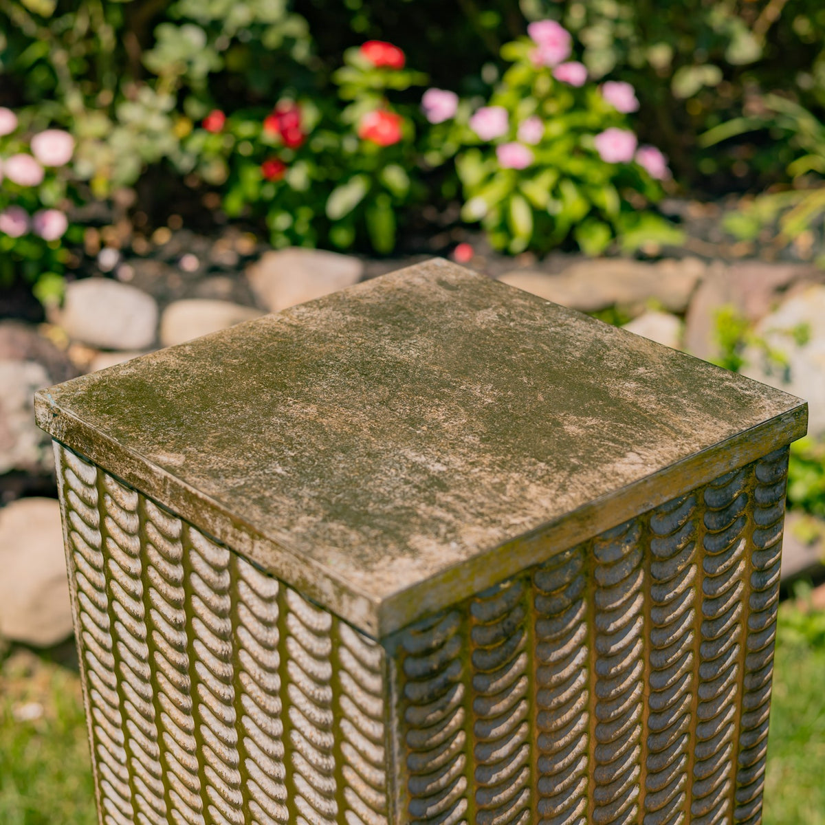 Angled close-up of a pillar’s mottled square top and textured gold-toned sides.