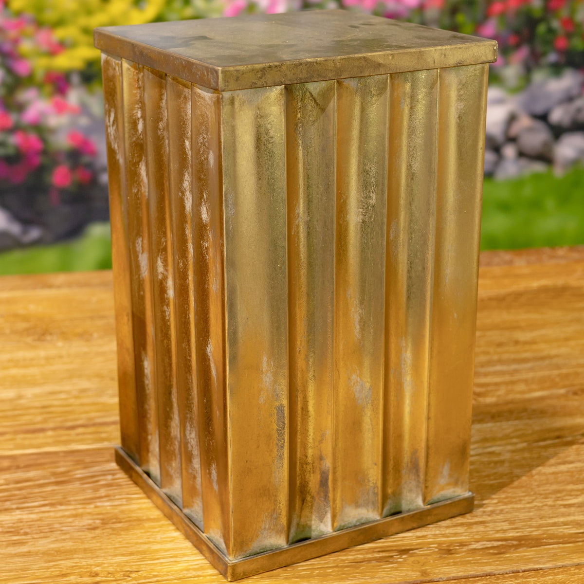 A gold-toned fluted metal pedestal pillar shown from another angle, with its square top and base visible.