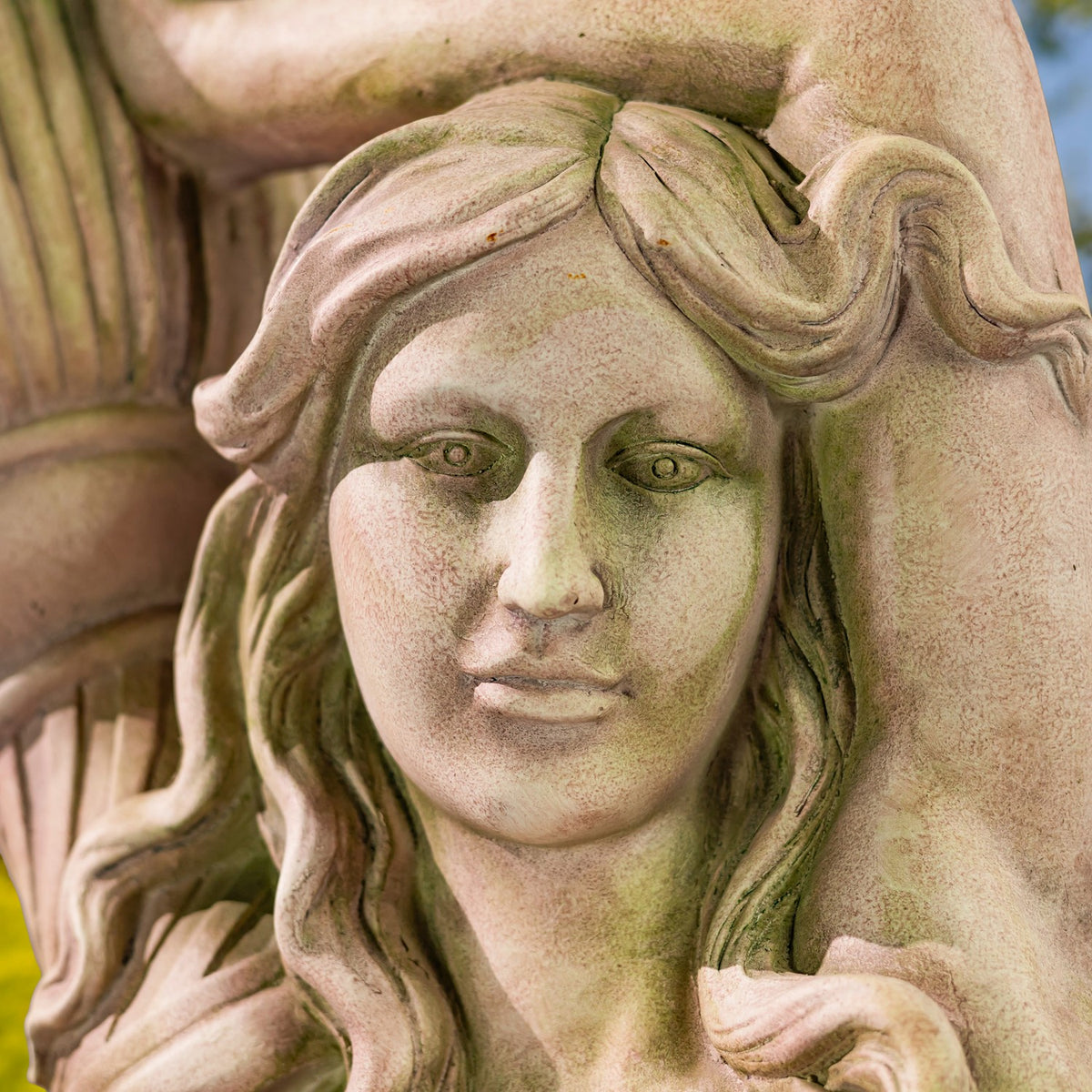 Close-up of the statue’s calm face and wavy hair, with part of the pot visible behind her.