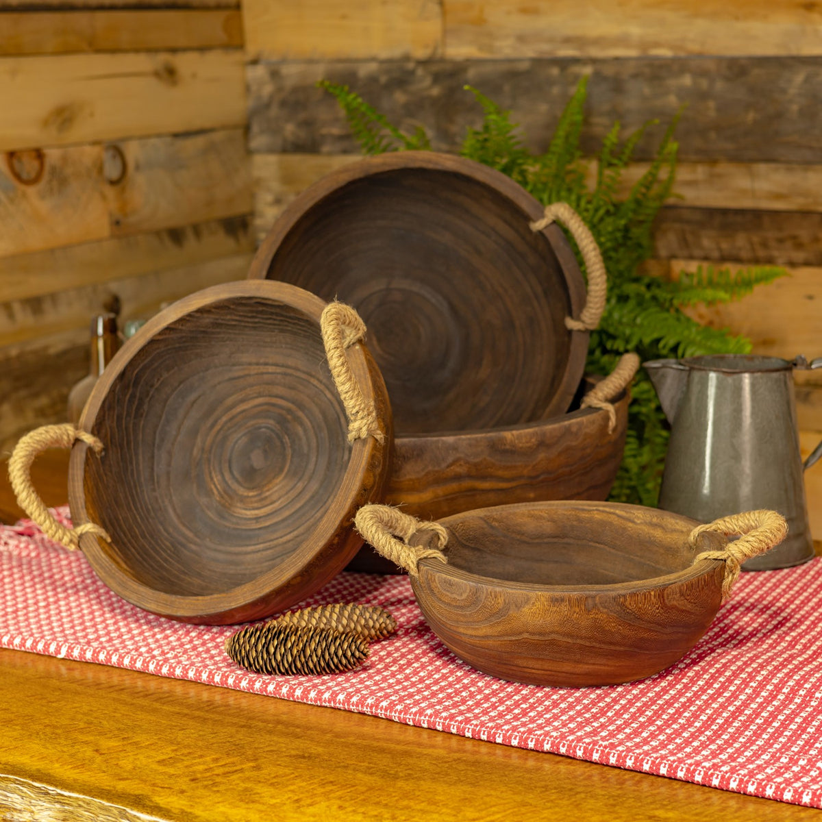 Several wooden trays are displayed upright and nested, with rope handles visible on the table.
