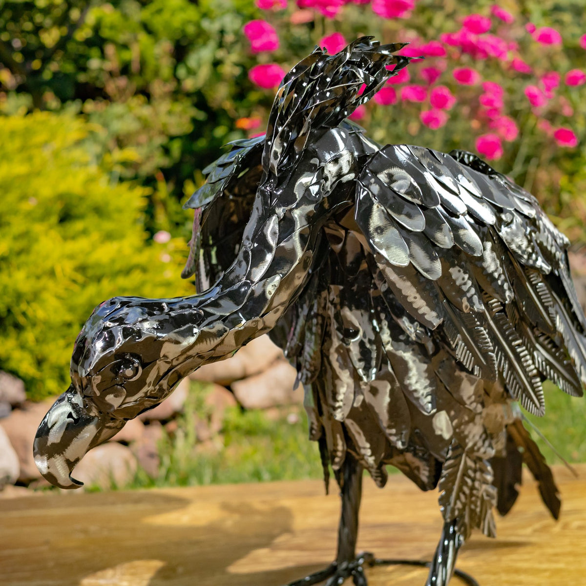 Close-up of a metallic vulture figurine's head, neck, and textured feathers
