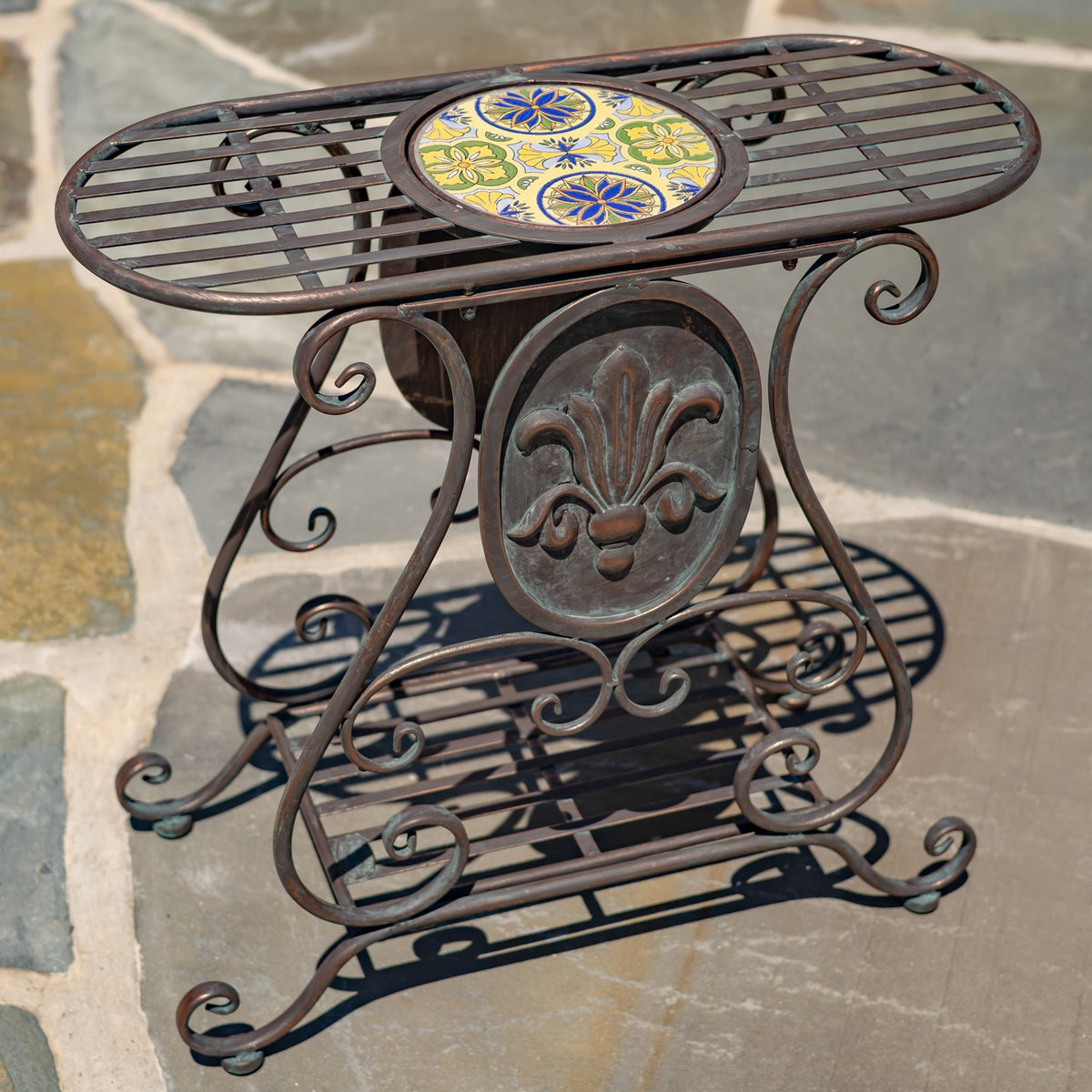 Close-up of the stand’s colorful circular mosaic inset, slatted top, and decorative metalwork.