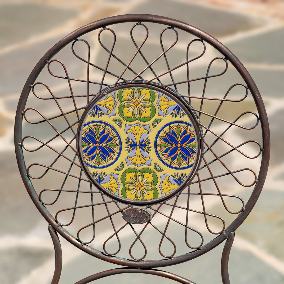 Close-up of the chair's circular back, showing a yellow, blue, and green floral tile pattern.
