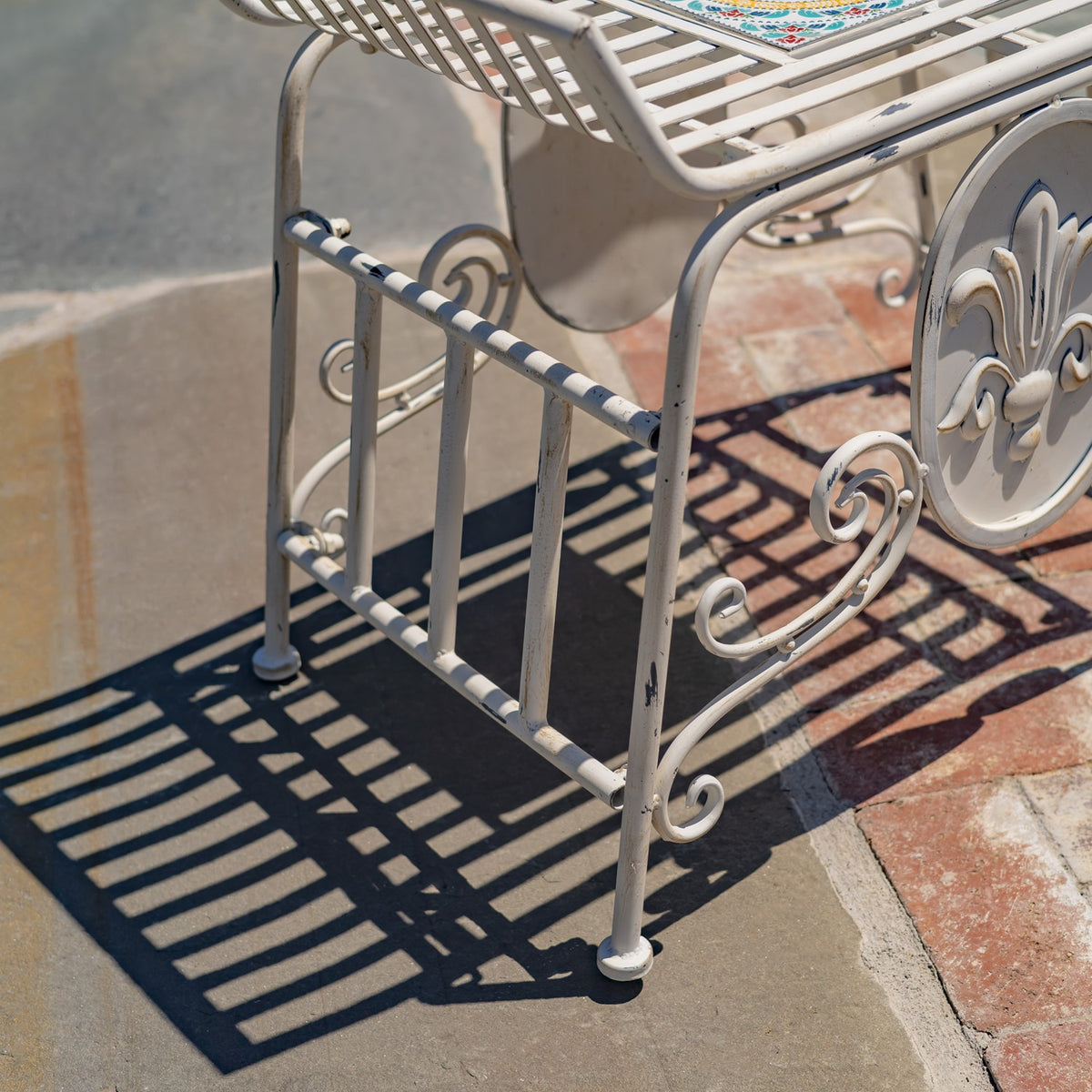 Close-up of the chair's striped lower side rail, curved supports, and ornamental scrollwork.