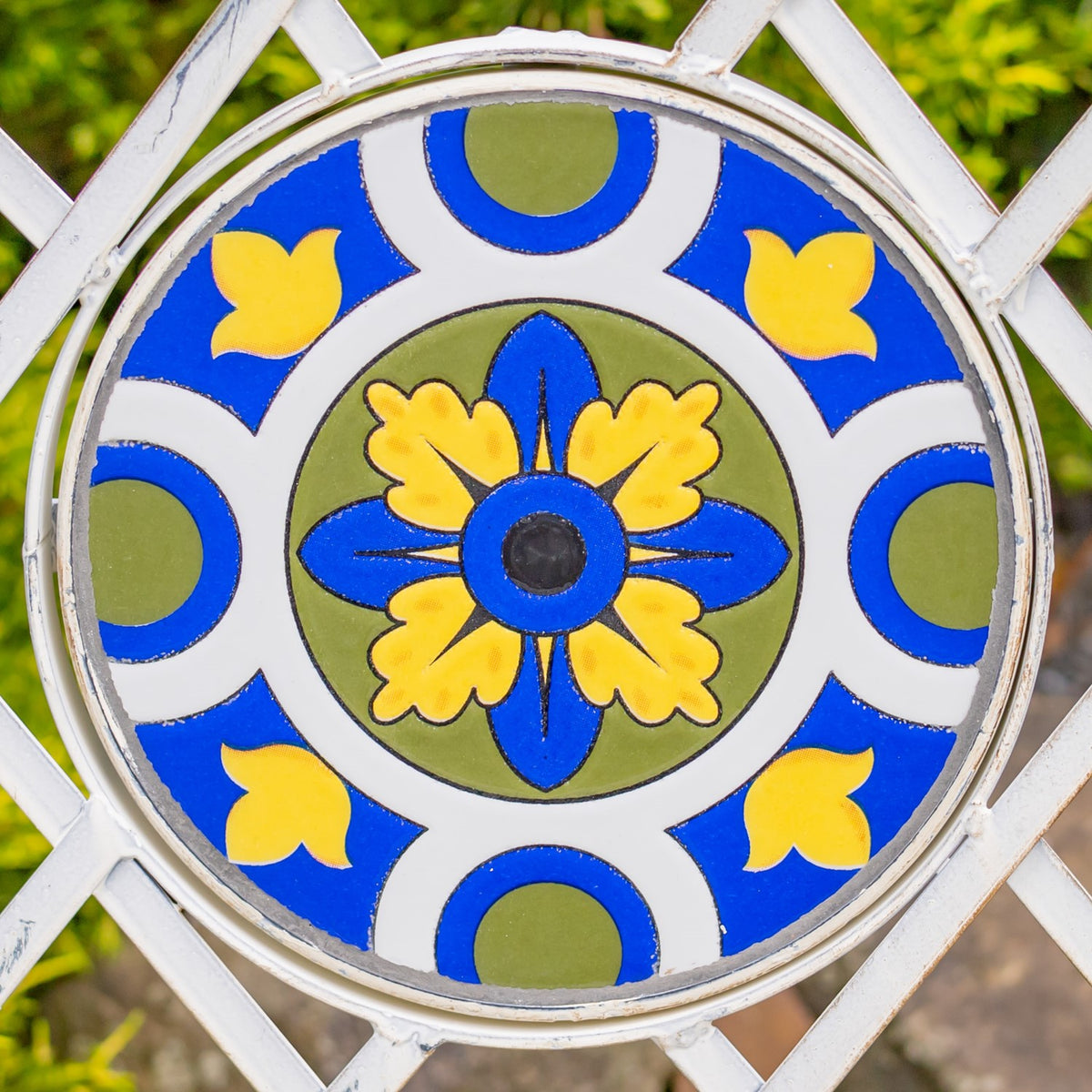 Close-up of a round tile medallion with a blue-and-yellow floral pattern.