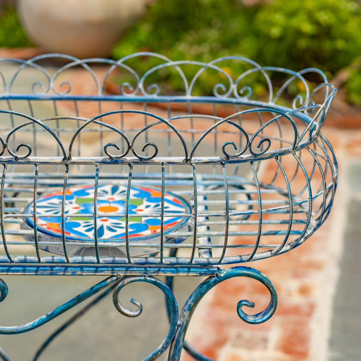 Close-up of the stand’s curved wire basket, scalloped rim and colorful mosaic base.