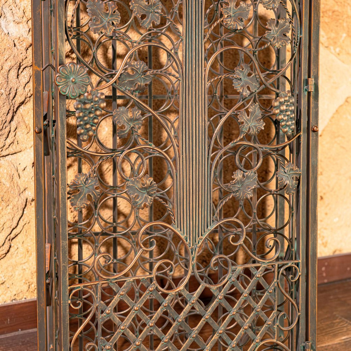 Close-up of ornate iron grape and vine motifs across the cabinet doors.