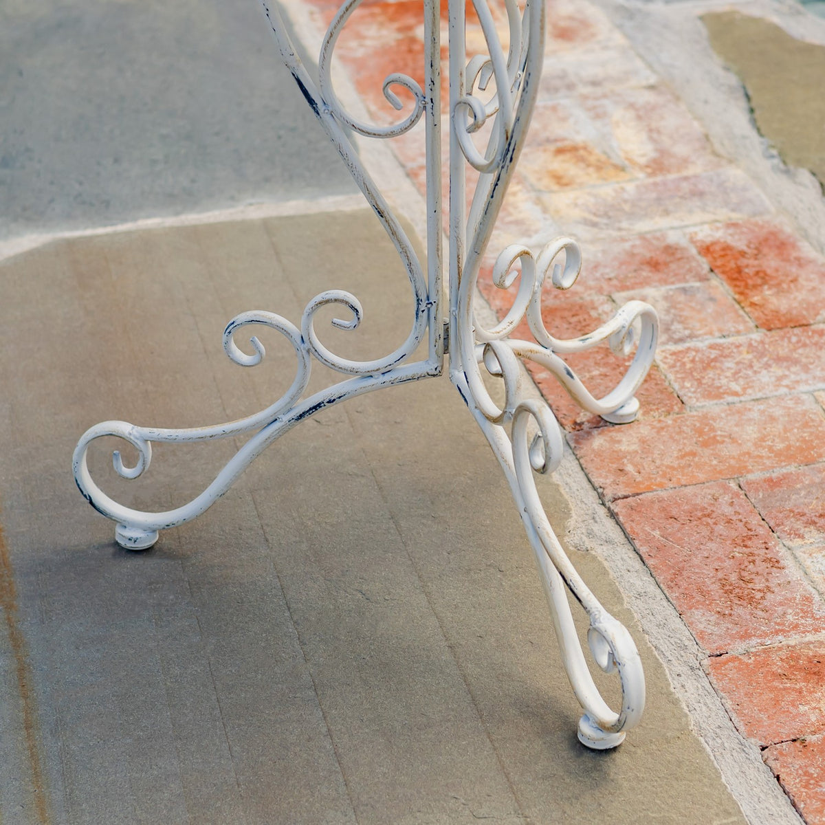 Close view of the stand’s curled metal feet resting on the patio.