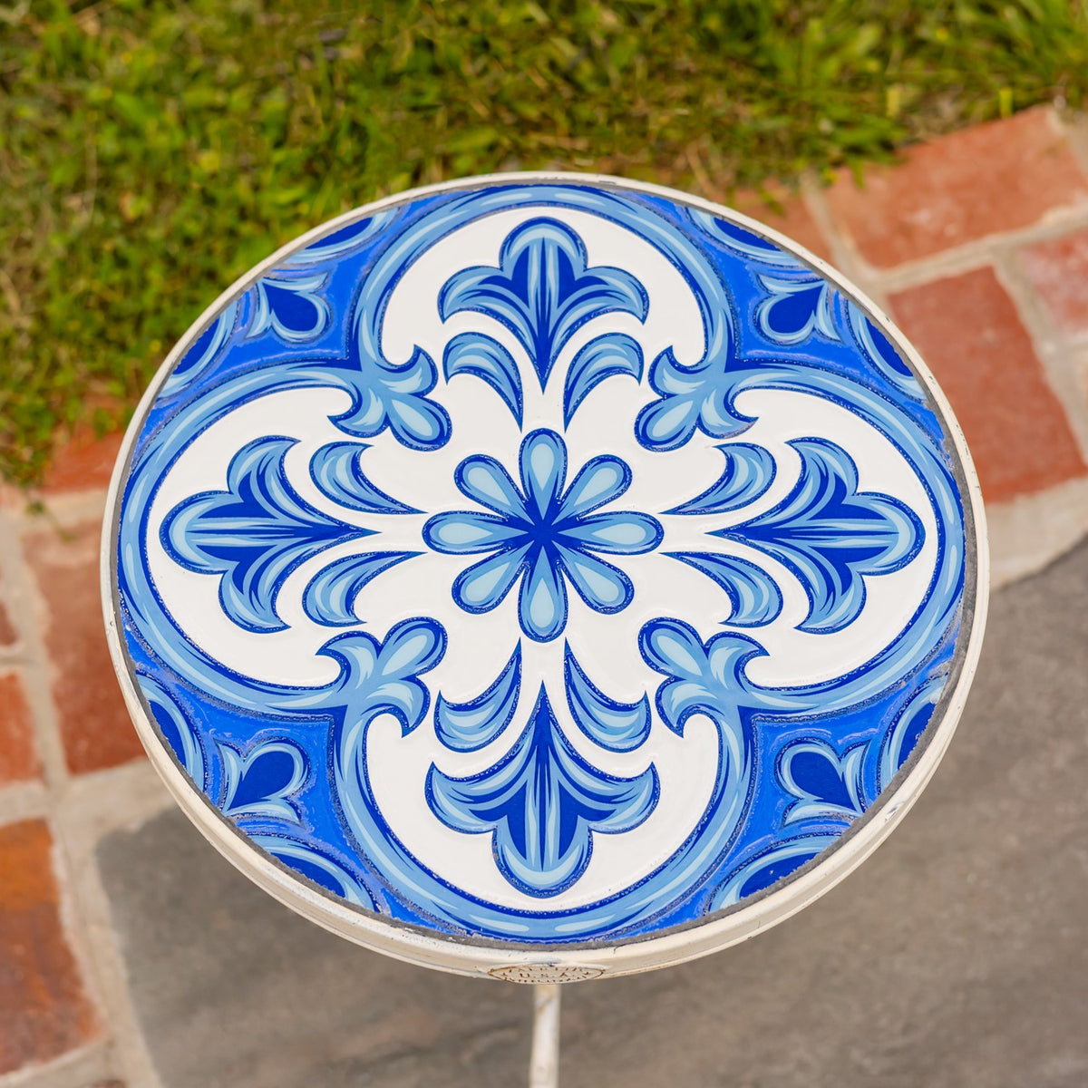 Overhead view of the round tabletop, showing its symmetrical blue-and-white floral mosaic pattern.